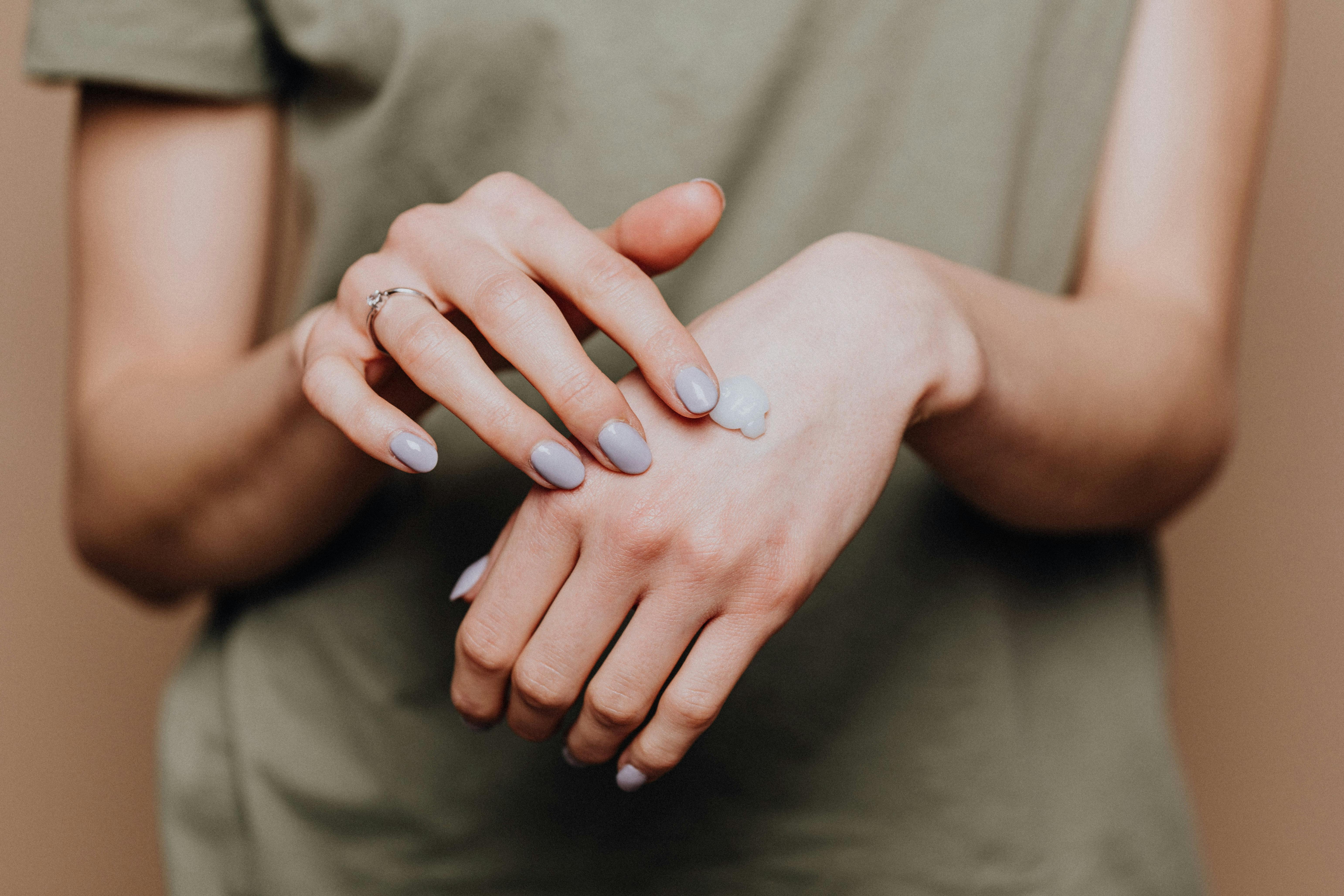 woman applying serum, close up of hands